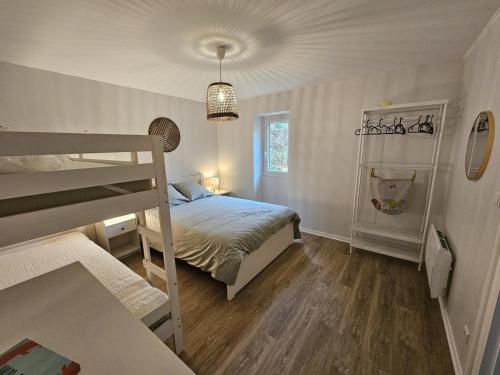 een slaapkamer met een bed en een stapelbed bij Maison perouge in Soustons