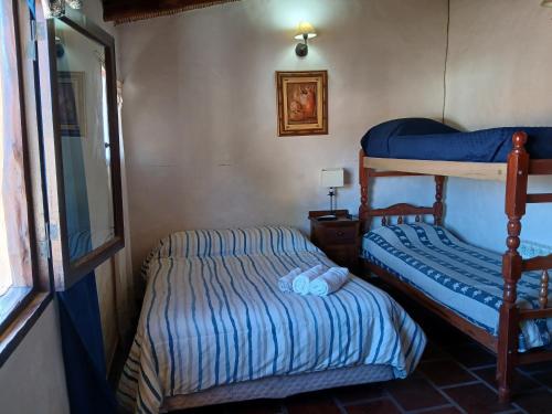 a bedroom with two bunk beds and a mirror at Hotel La Herencia in Tilcara