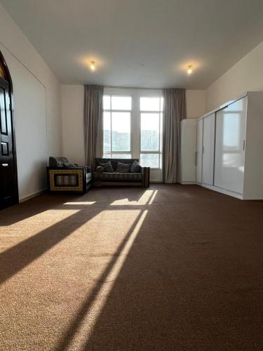 a living room with a couch and a large window at Suite Room Khalifa A1 in Abu Dhabi