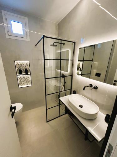 a white bathroom with a sink and a shower at Ghini Venes 3 in Tríkala