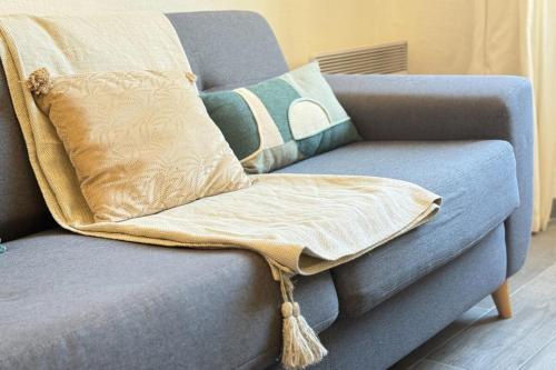 1-bedroom appartement in the center of Cannes في كان: بطانية على أريكة زرقاء عليها وسائد
