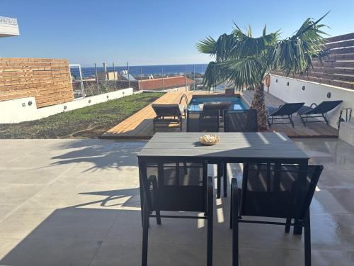 un tavolo e sedie su un patio con spiaggia di Sea View Sunrise Luxury Apartment a Città di Rodi