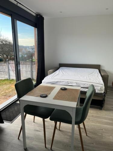 una camera da letto con un letto, un tavolo e delle sedie di Sof tiny a Moyenmoutier