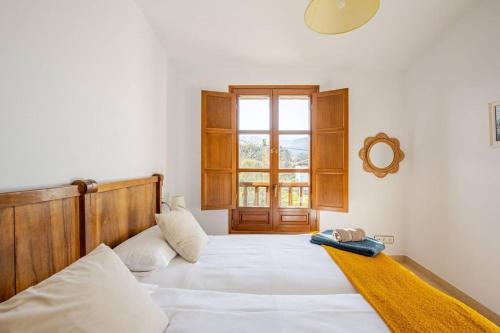 Un dormitorio con una cama blanca grande y una ventana en Celada Una casina con encanto, en Celorio
