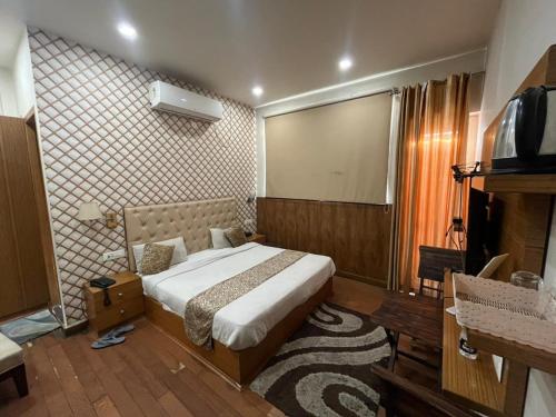 een slaapkamer met een bed en een televisie. bij Hotel LAVENIR in Rohtak