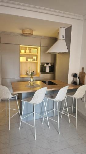 a kitchen with a wooden table and white chairs at Paradiso de Playa LaMata in La Mata