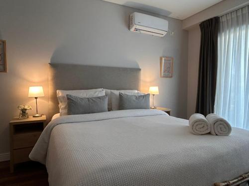 a bedroom with a large white bed with towels on it at Soar Luxury Studio en el centro de Salta in Salta