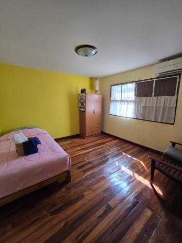 una camera da letto con un letto e un pavimento in legno di บ้านเขียมเลียบคลอง โฮมสเตย์ a Ban Ko Thuat