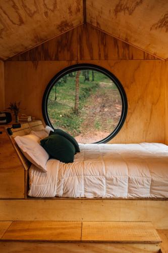 a bed in a small room with a window at Cabana Fora in São Francisco de Paula