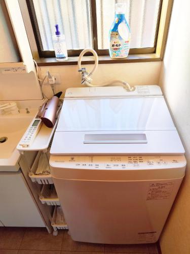 a washing machine in a room with a window at ビーチ コンビニ 温泉徒歩4分以内 BBQ無料 12人OK 5LDK戸建貸切宿 White sun villa in Shirako