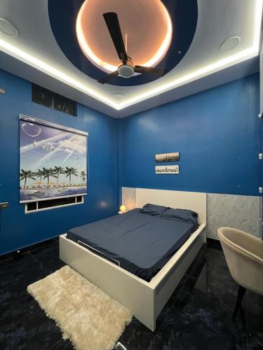 een blauwe slaapkamer met een bed en een plafond bij Riyaanz aesthetic in Hyderabad