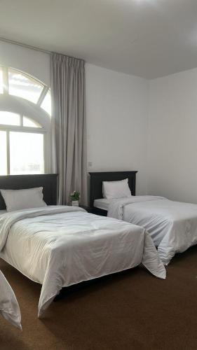 two beds sitting next to each other in a bedroom at Triple Room with 3 Single Beds A1 in Abu Dhabi