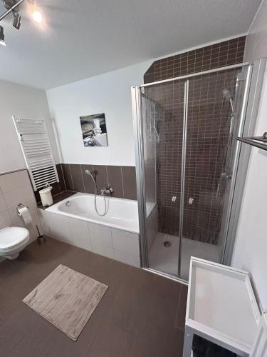 a bathroom with a shower and a tub and a toilet at Wagner Apartment Bayreuth FeWo - Erdgeschoss - nähe Festspielhaus - Free-WiFi - Schlafzimmer - Boxspringbetten - große Küche - Dusche - Badewanne - extra WC - Terrasse - DTV-Zertifiziert in Bayreuth
