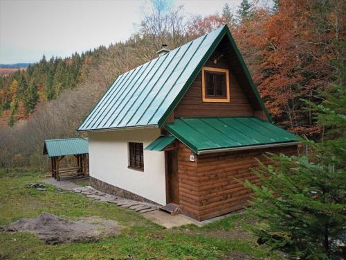 a small wooden cabin with a green roof at Chata Bachláč, Jarabá in Jarabá