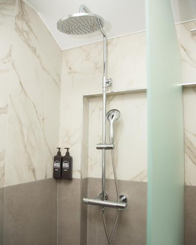 a shower in a bathroom with white marble walls at Datcha Tsaghkadzor in Tsaghkadzor