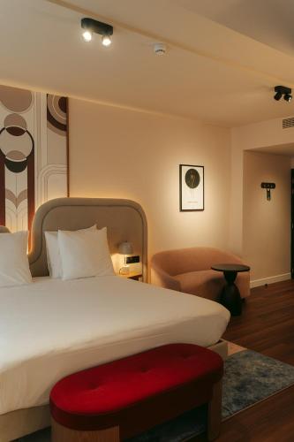 a bedroom with a large bed and a chair at Via Antwerp in Antwerp
