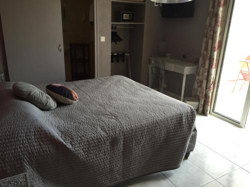 a bedroom with a bed with two pillows on it at Logis Hôtel Le Manoir & Lounge in Apt