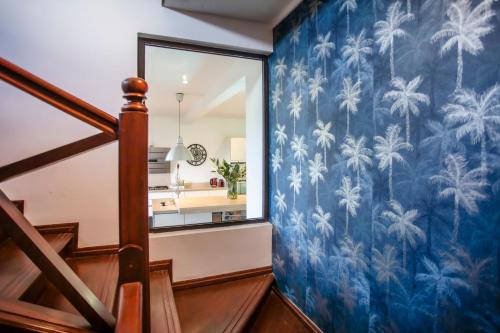 a staircase with a blue mural of palm trees at Private Villa Azure Garden with pool in Grand Baie