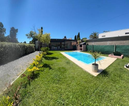 Un patio con piscina y una casa. en Casa quinta, en Carmen de Areco