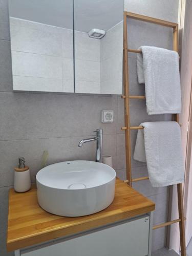un bagno con un lavandino bianco su un bancone di legno di Downtown Apartment Platanos a Panteli