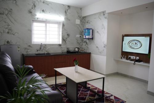 a living room with a table and a tv at KK Service Suites in Coimbatore