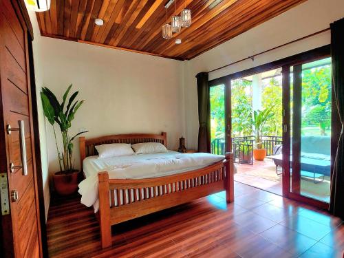 une chambre avec un lit et une porte coulissante en verre dans l'établissement Baan Phangan, à Ko Pha Ngan