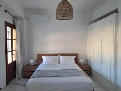 una camera da letto con un letto grande con lenzuola bianche di Downtown Apartment Platanos a Panteli