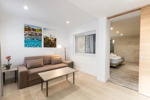 ein Wohnzimmer mit Sofa und Tisch in der Unterkunft Hotel Levante in Es Pujols