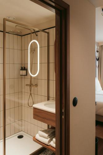 a bathroom with a shower with a tub and a sink at Via Antwerp in Antwerp