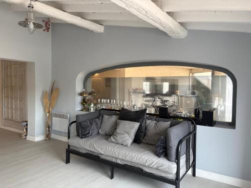 a couch in a living room with a mirror at Le Gite de Fanny in Saintes-Maries-de-la-Mer
