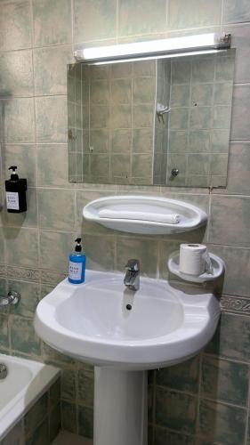 a bathroom with a white sink and a mirror at SM Room A1 in Abu Dhabi