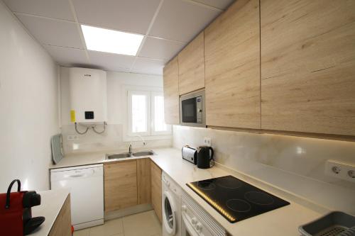 una cocina con fregadero y estufa horno superior en Casa Lara, en Miami Platja