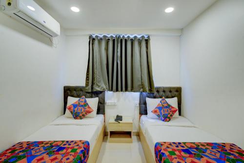 ein Zimmer mit zwei Betten und einem Fenster in der Unterkunft FabHotel Wild Wings Gachibowli in Hyderabad