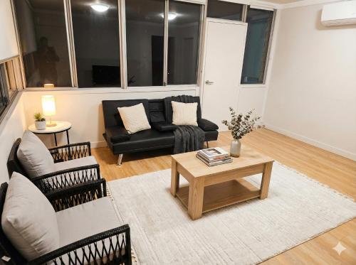 a living room with a couch and a coffee table at Huge 3Bed House and Backyard & 4 Car Park spaces and Near Parramatta in Wentworthville