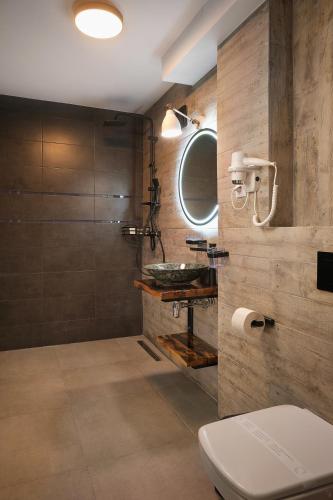 a bathroom with a sink and a toilet and a mirror at Independentei Central Apartaments in Iaşi