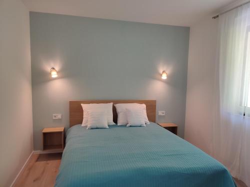 Un dormitorio con una cama grande con dos almohadas. en Katáng Vendégház, en Tardosbánya