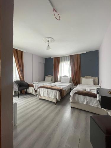 a hotel room with three beds in it at Karya Hotel in Kuşadası