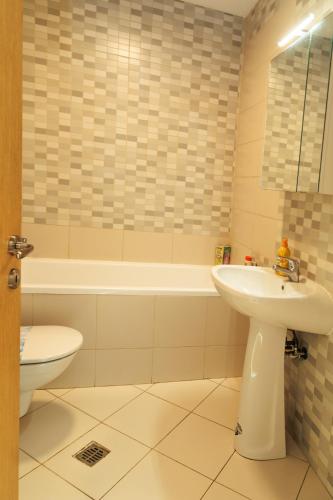 a bathroom with a sink and a tub and a toilet at Bucharest Central E Apartment in Bucharest
