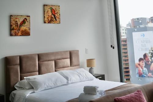 a bedroom with a bed with two pictures on the wall at Seis Residences in Quito