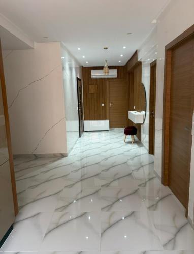 a lobby with white marble flooring and a door at Licht & ruim 2-slaapkamer appartement met airco & Wifi - rustig wijk Marrakesh in Marrakesh