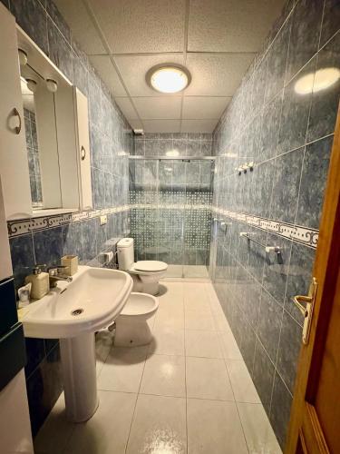 a bathroom with two toilets and a sink and a shower at Apartamento La Magdalena in Llanes