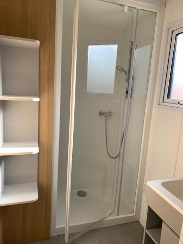 eine Dusche mit Glastür im Badezimmer in der Unterkunft Le Beaupré - prestation hotelière in Mesquer