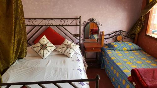 a bedroom with two beds and a mirror at Kasabah Senhaji in Moulay Idriss Zerhoun