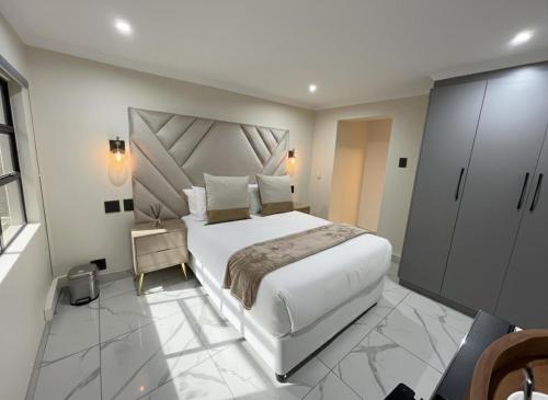 彼得马里茨堡The Corner Guesthouse的卧室配有白色大床和橱柜