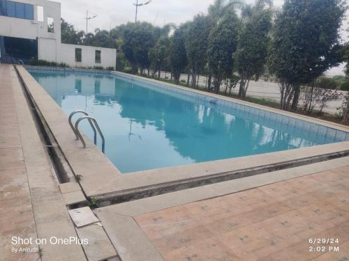 una piscina con agua azul en un edificio en Luxury Villa Rooms Phamacity Genome Valley, en Turkapally