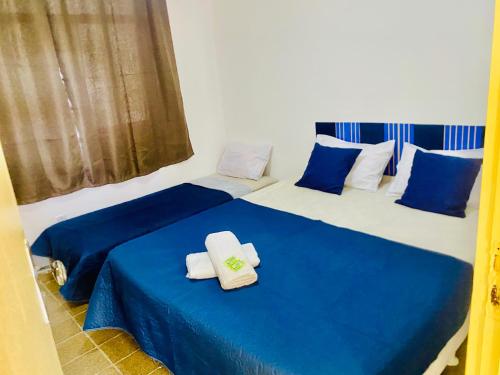 サルバドールにあるPPousada 03 min da praia, Itapuaの青と白の部屋にベッドが2つある