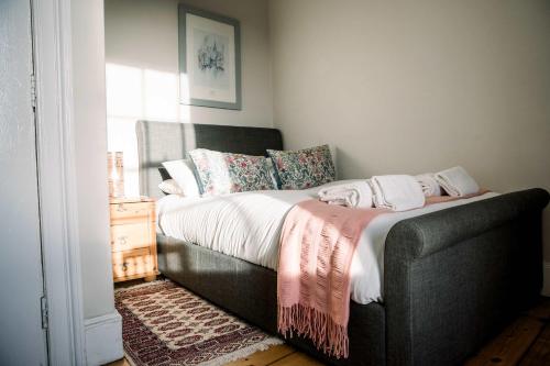 a bedroom with a bed with a black couch at 3 Bed Traditional Apartment on Picturesque Victoria St in Edinburgh