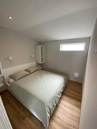 a bedroom with a large bed with a window at Appartement Oisterwijk in Moergestel