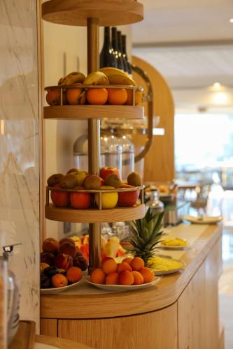 Una exhibición de frutas en platos sobre un mostrador. en Best Western Premier Santa Maria, en LʼÎle-Rousse