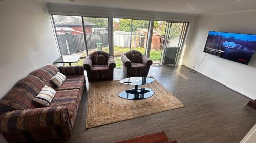 a living room with couches and a flat screen tv at Frankston Vacation Home in Frankston East